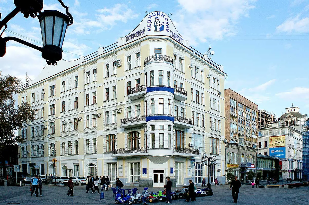 A cream and blue university building with its name in Russian across the roofline
